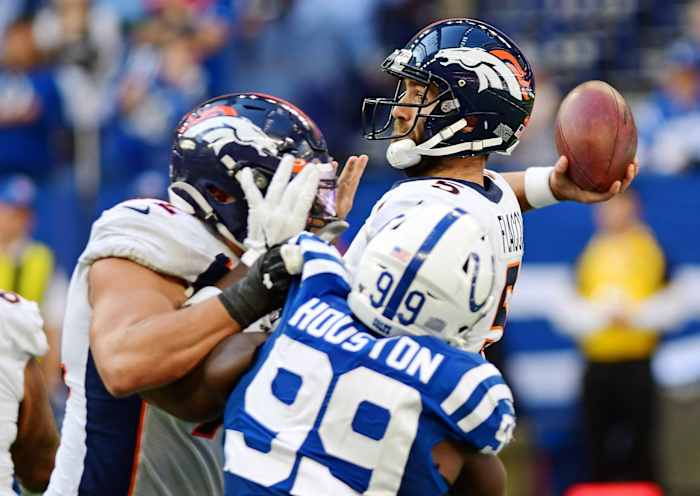 Denver Broncos quarterback Joe Flacco (5) drops back to pass against the Indianapolis Colts in the fourth quarter at Lucas Oil Stadium.